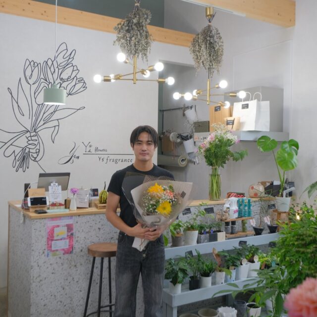【千歳市勇舞】寄り添う花屋「Y’s flowers」さまご紹介(前編)
千歳市勇舞にお花屋さん「Y’s flowers」をオープンさせた山根勇人さん。お客様のストーリーを大切にする接客と商品づくりで4年連続で売り上げは前年超え。2024年には、生杉建設が新店舗の設計施工を担当させていただきました。山根店長にお話を伺いました。
Q お花屋さんを開業する前はどんなお仕事を?
ウェディングプランナーを12年、900組以上のお客様の結婚式を担当させていただきました。
Q ウェディングプランナーになったきっかけは?
私は双子なんですが、片割れが17歳で結婚した時、結婚式で、両親へ感謝の言葉を泣きながら話していて、高校生ながら、結婚式って人生の大切な区切りなんだ、参列してくれている方々が応援団になるから、この2人は強く生きていけるんだ、結婚式ってとても大切だなと思ったんです。
その場で支配人に「ここで働かせてください」とお願いしたら「1年社会人経験をして、1年後まだやりたいと思っていたら来てください」と言われ、新千歳空港でANAのグランドスタッフをしてから、ウェディングプランナーの道に入りました。
Q ウェディングプランナーからお花屋さんへの経緯を教えてください
新郎新婦のお人柄や思いを深く理解し、思いを叶えることに私の100%以上をつぎ込む、約束を守るのは当たり前で失敗はあり得ないという姿勢で12年働きました。1日に5組を担当することもある多忙な日々でしたが、結婚式の後に「山根さんに担当していただいてよかった」と言っていただけることが励みでした。
ある日、友人が亡くなり、お花屋さんに行くと、とても残念な接客を受けてしまいました。お花屋さんはお祝い事や、逆にとても悲しい時に訪れる場所です。お客様の気持ちに寄り添えるお花屋さんがあればいいのにと思い、これは自分でお花屋さんをやろうと思ったんです。ウェディングプランナー時代から綺麗なものを作るのが好きだったこともあり、お花屋さんという仕事にも魅力を感じました。翌日には会社に辞表を出し、お花屋さんの準備に入りました。
Q 行動力が凄いですね
即決即断するタイプなんです。たとえ苦労をしても自分と愛犬が贅沢しなければ生きていけるくらいの収入さえあればあとは何とでもなる、もしお客様がこなければ、町に繰り出して営業すればいいと思っていました。
@ys.flowers.official 
続く・・・